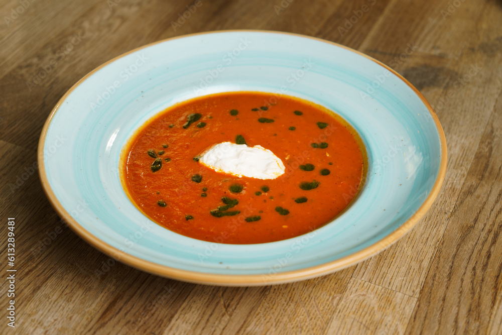 High angle view of Tomato Soup with burrata and homemade pesto on a wooden table High angle view of Tomato Soup with burrata and homemade pesto on a wooden table