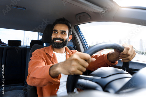 Smiling Bearded Indian Man Driving Auto Sitting In Driver's Seat