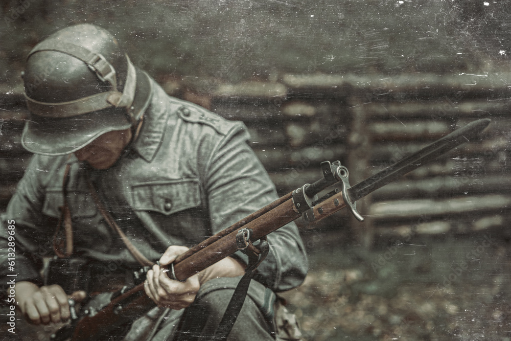A soldier of the Finnish army during the Second World War with a gun in his hands.Bayonet knife on a wooden rifle.A soldier in an iron helmet reloads his weapon.