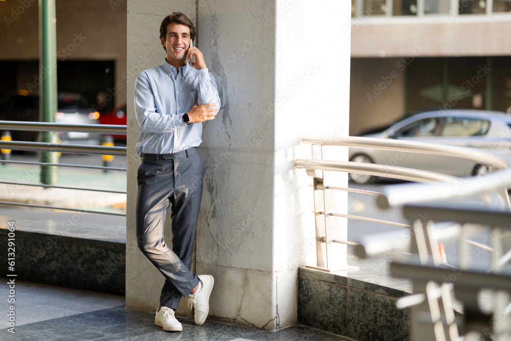 Portrait of happy businessman talking on phone outdoors
