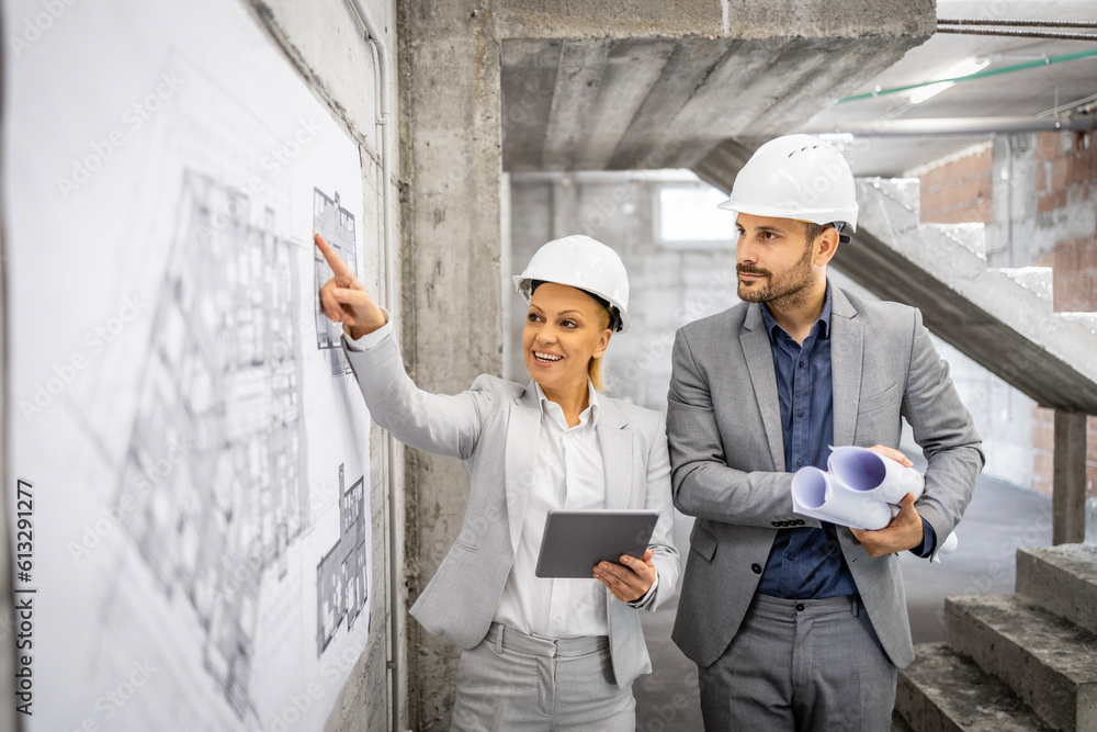 Construction inspectors working together at the site, controlling and inspecting building process. Looking at project plan and blueprint. Construction inspectors working together at the site, controlling and inspecting building process. Looking at project plan and blueprint.