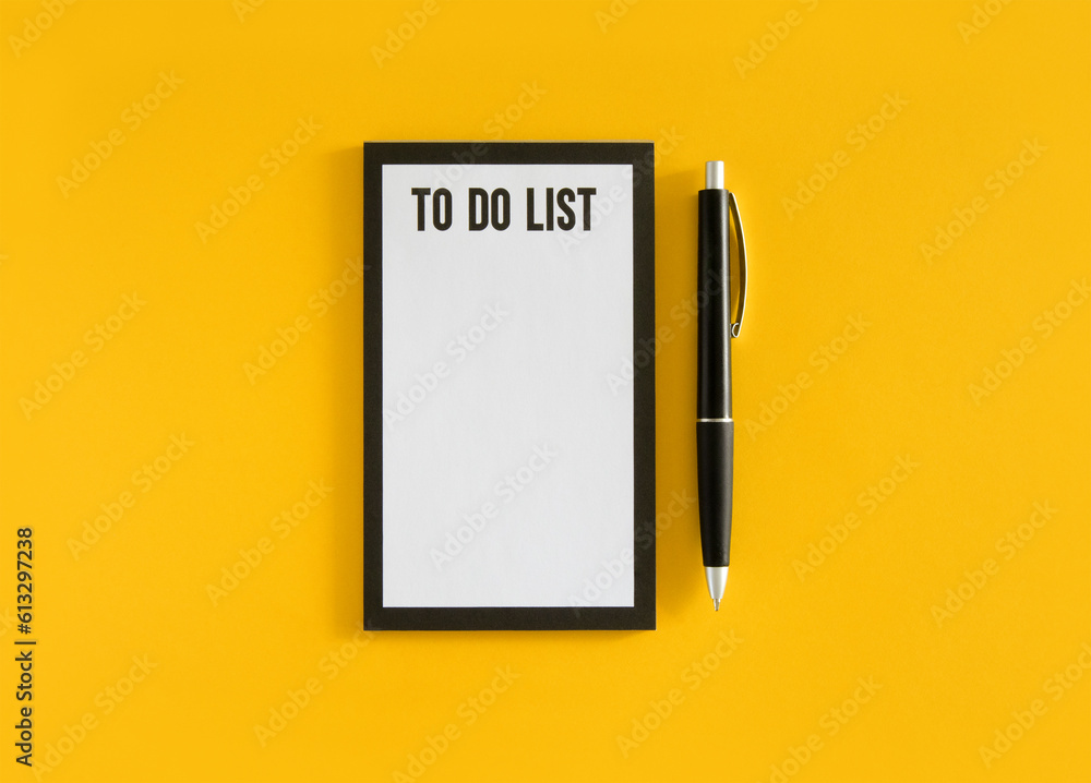 White sheet with to do list phrase and black pen on yellow background. Stock photo. White sheet with to do list phrase and black pen on yellow background. Stock photo.