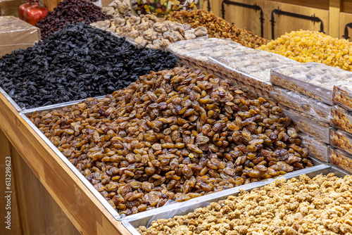 Raisins are heaped on the counter of a store or in the market. Dried fruits. Golden dried grapes without seeds on the market counter. © mehmet