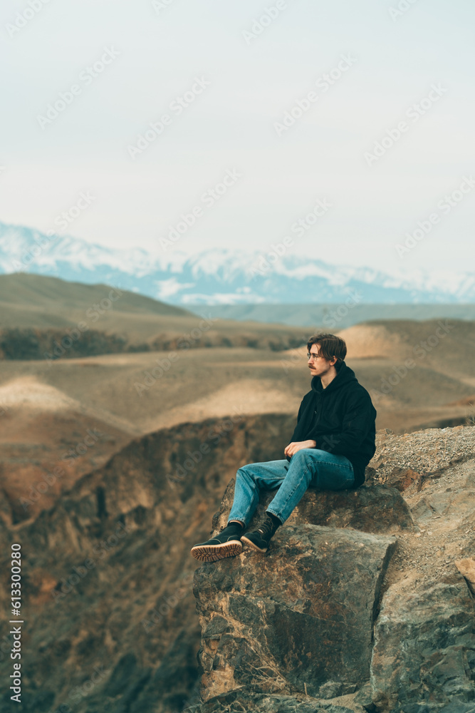 a handsome guy with glasses and a mustache sits on the edge of a cliff a handsome guy with glasses and a mustache sits on the edge of a cliff