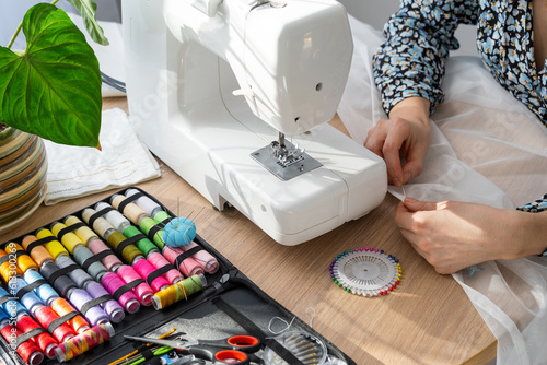 Bild auf Leinwand Woman hand close up sews tulle on electric sewing machine