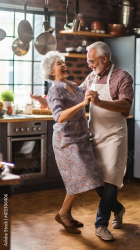 Cheerful grey-haired seniors enjoying dancing tango after cooking dinner in kitchen