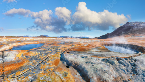 Breathtaking boiling mudpots in geothermal area Hverir and cracked ground around. photo