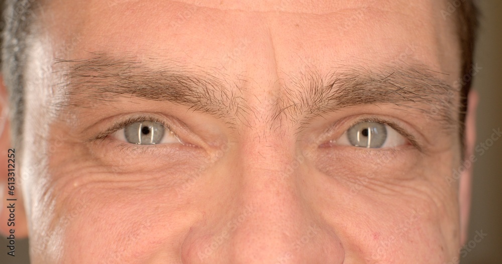 Motivation with positive mood. Close-up of men's eyes blinking, looking intently into the camera. Visual contact, blin. Narrow pupil of the eye. Motivation with positive mood. Close-up of men's eyes blinking, looking intently into the camera. Visual contact, blin. Narrow pupil of the eye.