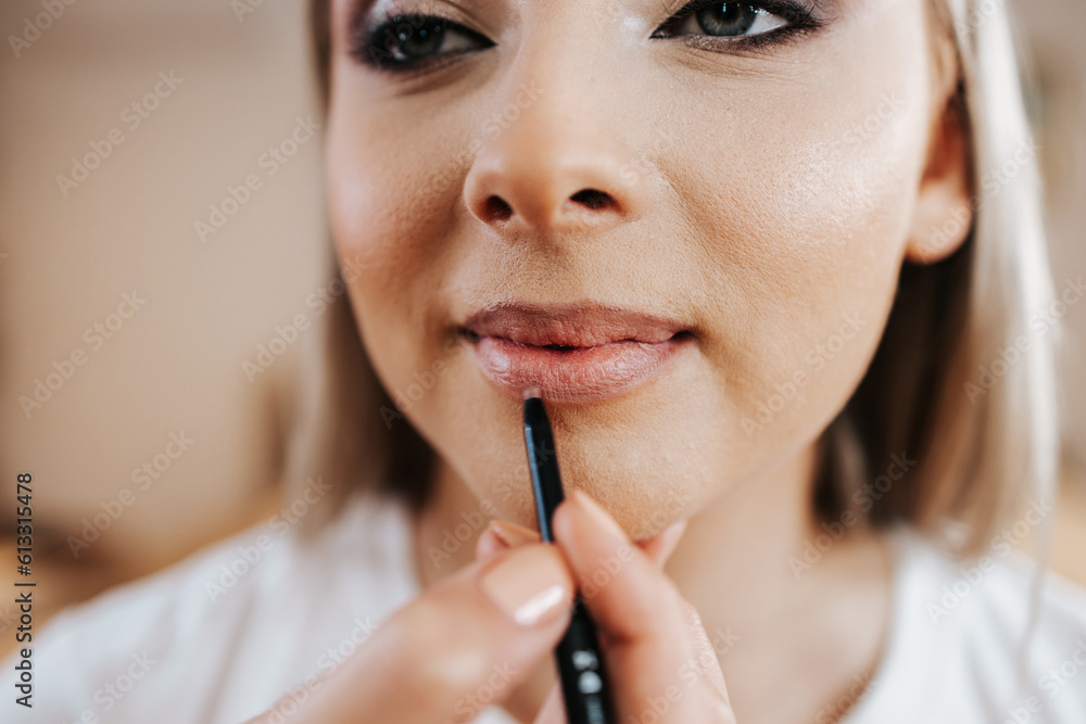 Makeup process. Professional artist applying make up on model face. Close up portrait of beautiful blonde woman in beauty salon. Makeup process. Professional artist applying make up on model face. Close up portrait of beautiful blonde woman in beauty salon.