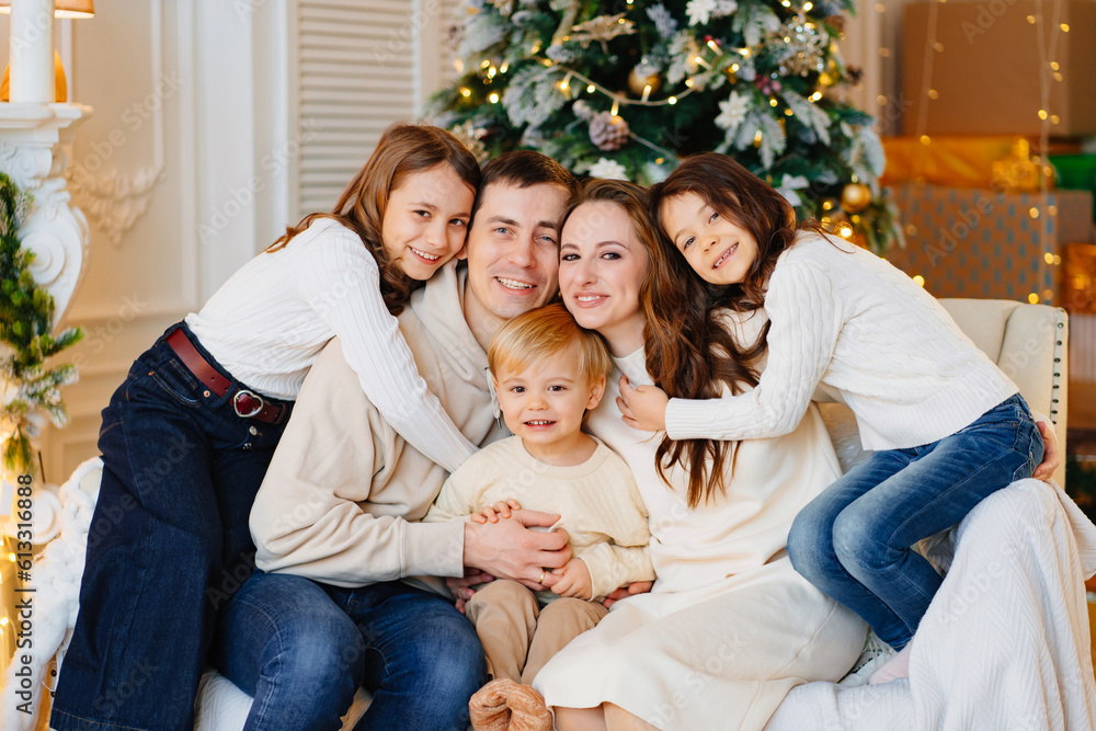 Beautiful happy large family on the couch by the Christmas tree.