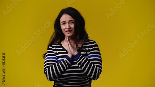 4k video of one woman begging for something on yellow background.