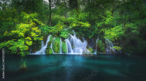 Waterfall in green forest in Plitvice Lakes, Croatia at sunset