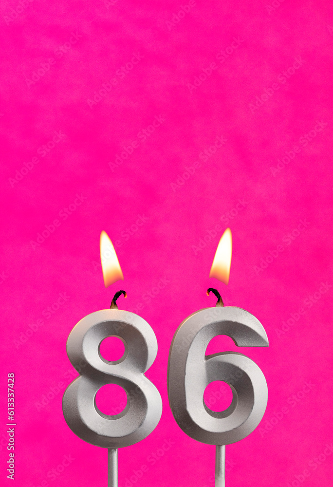 Candle number 86 - Birthday celebration on fuchsia background Candle number 86 - Birthday celebration on fuchsia background