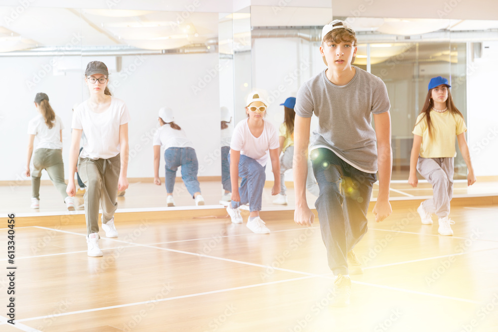 Happy positive teenagers learn dance movements in dance class
