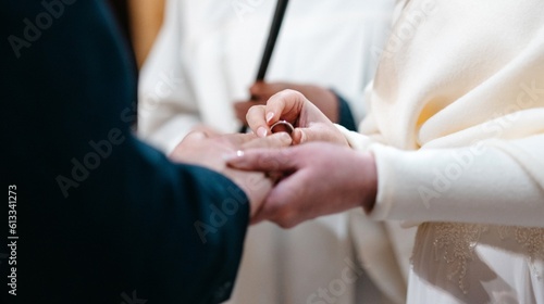 Wedding ring and hands of bride and groom, young wedding couple at ceremony in church