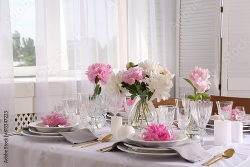 Stylish table setting with beautiful peonies in dining room © New Africa