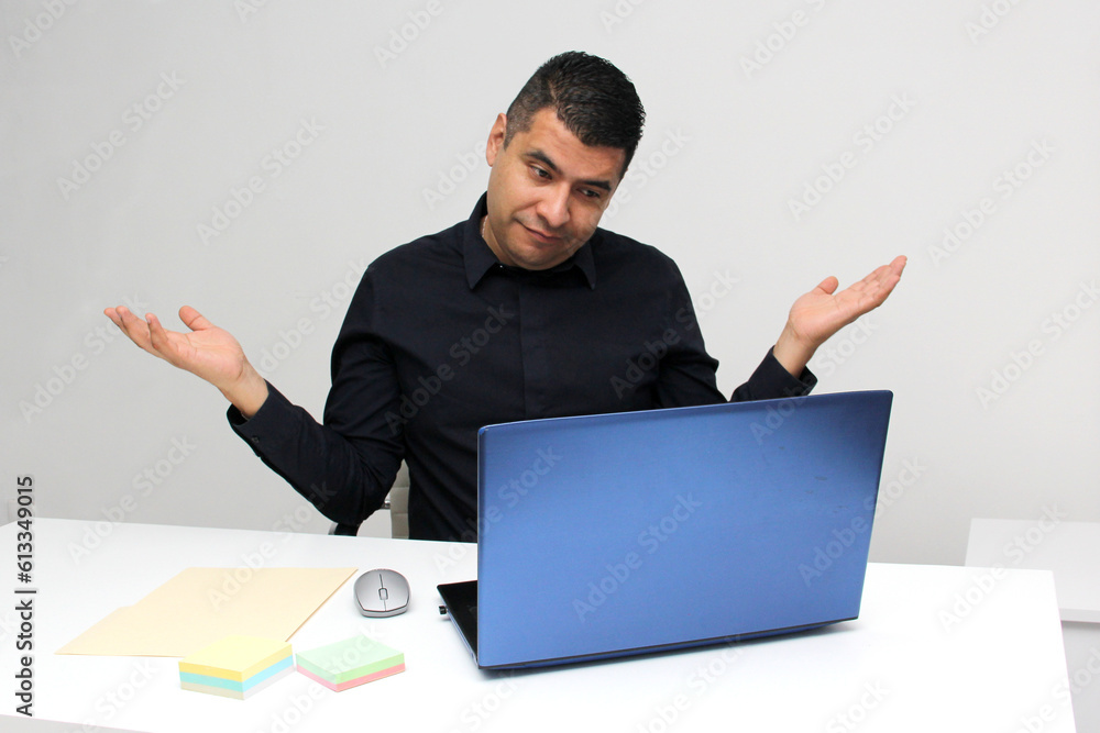 Dark-haired 40-year-old Latino man works in his office with his laptop, suffering from stress and despair due to work pressure Dark-haired 40-year-old Latino man works in his office with his laptop, suffering from stress and despair due to work pressure