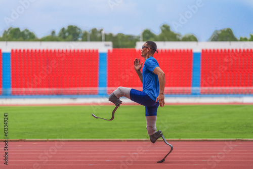 An Asian speed runner athlete with two prosthetic blades is captured practicing his speed running on the stadium's track