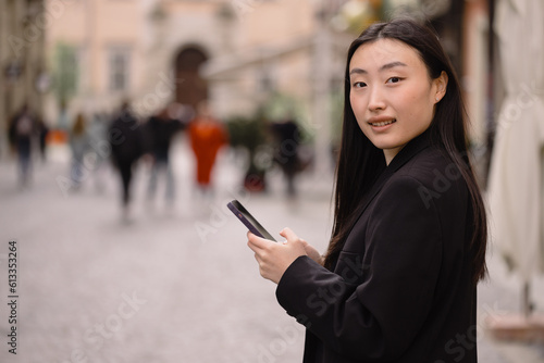 Portrait of a beautiful Korean woman. Asian woman in casual clothes talking on the phone, modern technology and lifestyle.