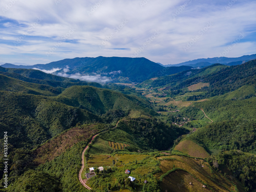 Drone shot at Sky Road, Huai Thon Village, Unseen Nan Village, Thailand, located in a complex valley, winding along the ridge of the forest. The view is very beautiful. The rainy season is green.