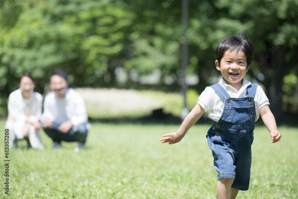 公園を走る子供と見守る親 保険や子育てのイメージに 公園を走る子供と見守る親 保険や子育てのイメージに