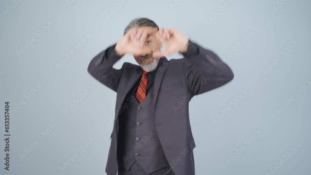 Businessman making heart at camera. Businessman making heart at camera.