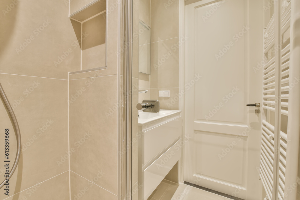 Obraz premium a modern bathroom with beige walls and white fixtures in the shower stall door is open to reveal a large mirror