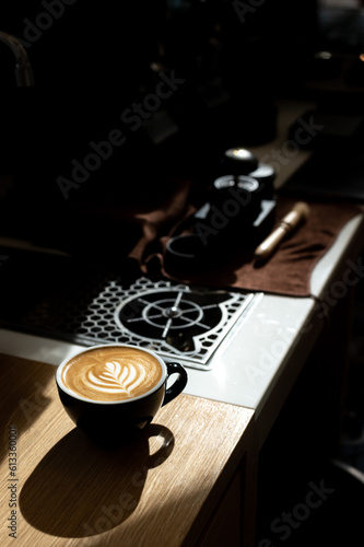 Cup of coffee with latte art on the wooden table.