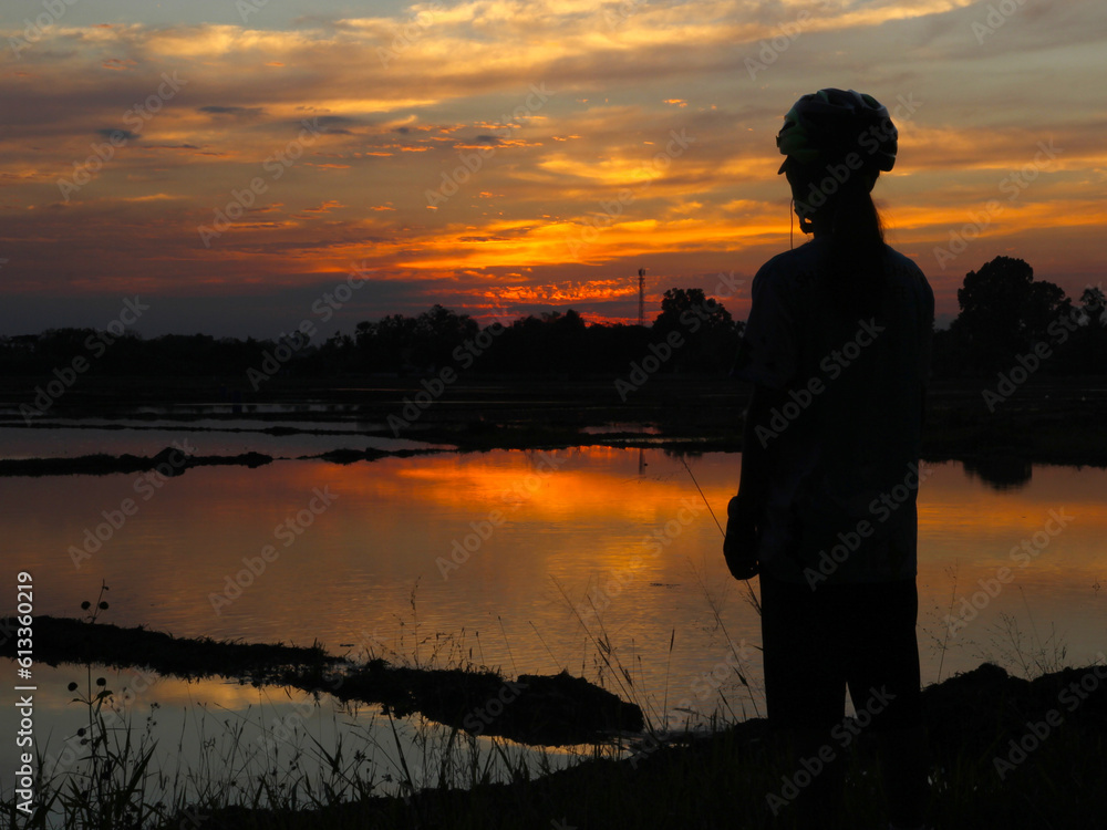 Fototapeta premium In the evening silhouettes of people standing watching the sunset with beautiful golden sky background.