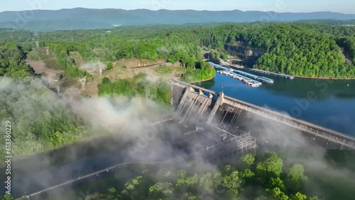 Early morning fog and mist over Norris Dam and Reservoir in lush green mountains of Tennessee during summer vacation while camping and boating