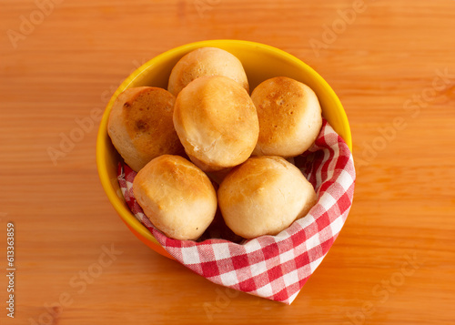 Cheese bread (Brazilian pao de queijo mineiro), focused, on a bowl, wooden table photo