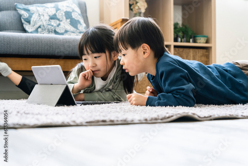 タブレットを見る日本人姉弟