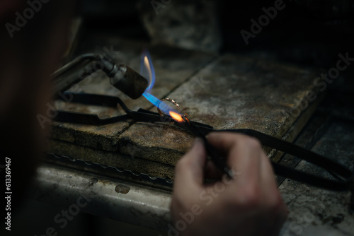 Craftsman is working by using a Gas spraying tool to make a ring