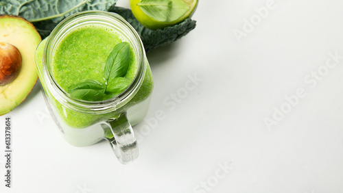 Healthy green smoothie in a jar mug on white background
