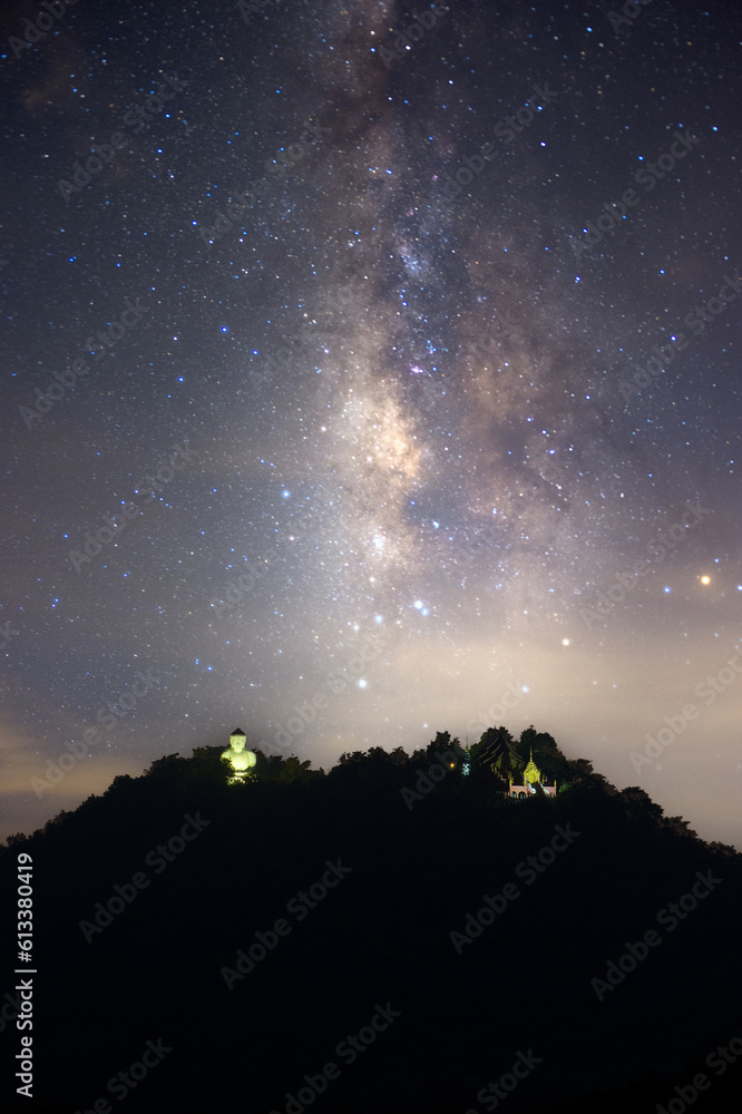 Stunning vertical Milky Way at night, big Buddha statue On a high mountain under a beautiful night sky, Mae Tha, Lampang. Stunning vertical Milky Way at night, big Buddha statue On a high mountain under a beautiful night sky, Mae Tha, Lampang.