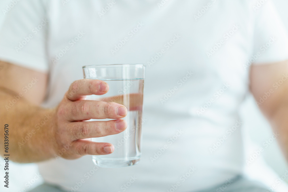 Caucasian white fat man drinks a water in a drinking glass in every morning. Caucasian white fat man drinks a water in a drinking glass in every morning.