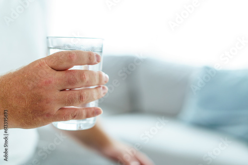 Caucasian white fat man drinks a water in a drinking glass in every morning.