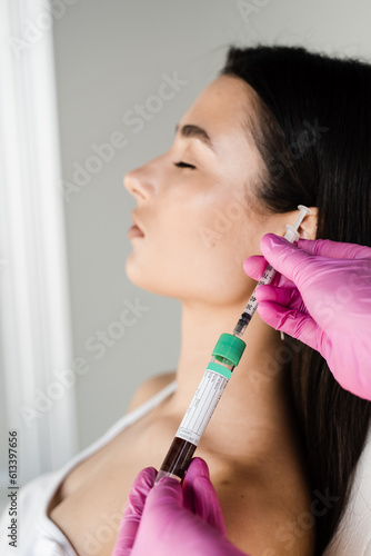 Platelet Rich Plasma PRP for improves skin volume and texture, reduces flaccidity and fine wrinkles. Cosmetologist with test tube with plasma of patient girl for PRP Platelet Rich Plasma procedure.