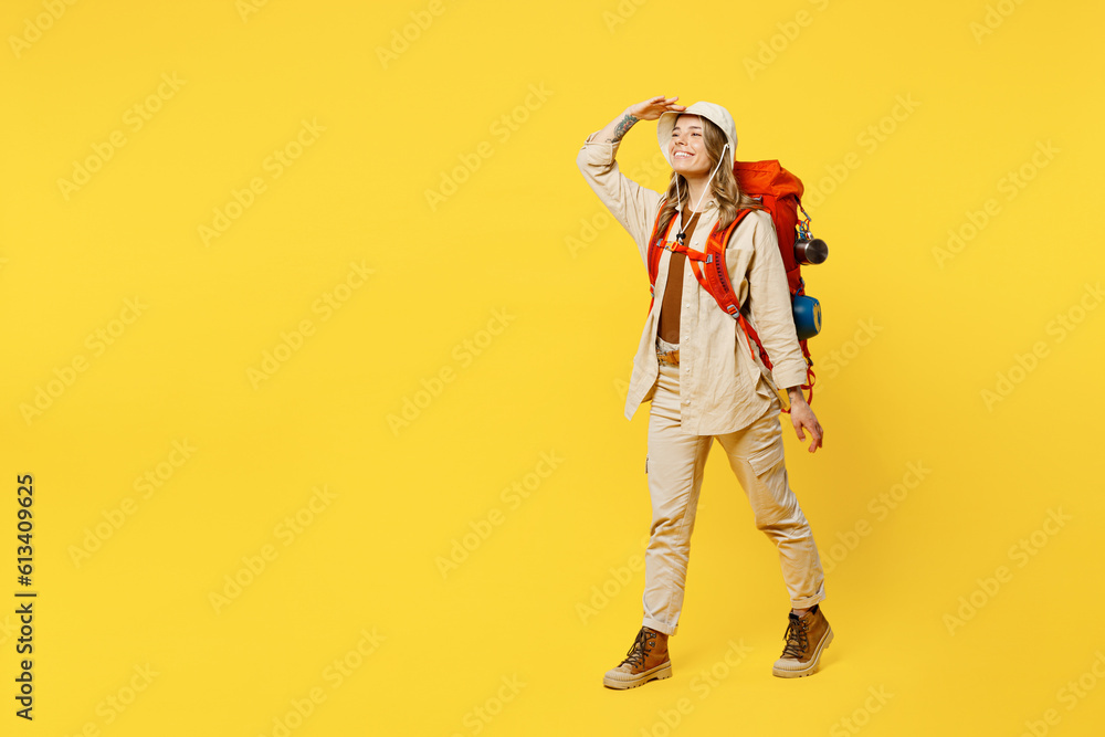Full body fun young woman carry bag with stuff mat look far away distance isolated on plain yellow background. Tourist leads active lifestyle walk on spare time. Hiking trek rest travel trip concept. Full body fun young woman carry bag with stuff mat look far away distance isolated on plain yellow background. Tourist leads active lifestyle walk on spare time. Hiking trek rest travel trip concept.