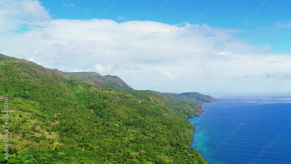 Aerial view of the green mountainous coast of the blue Atlantic Ocean. Amazing Caribbean coast. Summer trip to Latin America. Wildlife of the tropics from a bird's eye view. Ocean background. Cruise. Aerial view of the green mountainous coast of the blue Atlantic Ocean. Amazing Caribbean coast. Summer trip to Latin America. Wildlife of the tropics from a bird's eye view. Ocean background. Cruise.