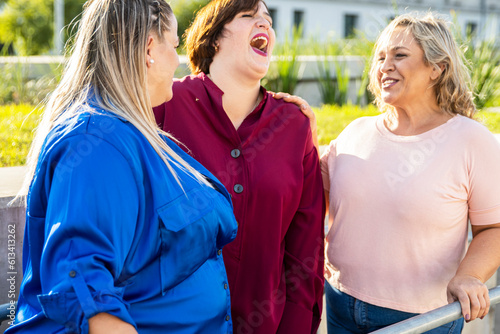 Three Latin Curvy Friends Catching Up in a joyful chat outdoors. Diversity, Acceptance, Femininity.