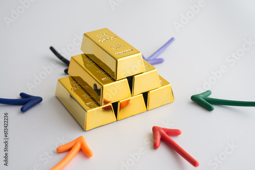Fototapeta Naklejka Na Ścianę i Meble -  Stack gold bars and arrow around on white background. Gold price increase rising in commodity trading bull market investment concept. Gold is store of value in recession crisis and popular investment.