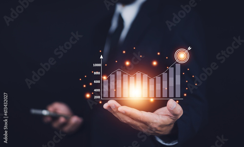 Businessman planning and strategy, Stock market, Business growth, progress or success concept. Businessman or trader is showing a growing virtual hologram stock, invest in trading.