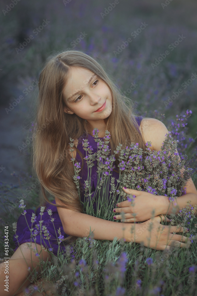 Young pretty dreaming girl in violet dress sitting in lavender field hugging flowers in Provence at sunset, vertical outdoor lifestyle portrait, idea of beauty, tenderness, relax and summer vibe Young pretty dreaming girl in violet dress sitting in lavender field hugging flowers in Provence at sunset, vertical outdoor lifestyle portrait, idea of beauty, tenderness, relax and summer vibe