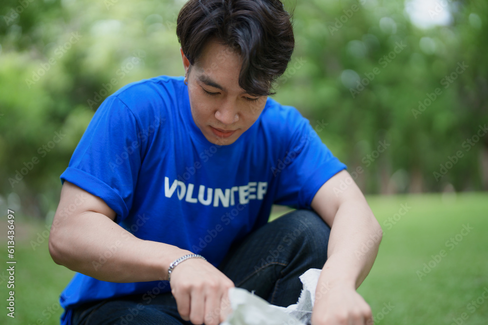 Multiethnic volunteers donate their time holding black garbage bags to collect plastic waste for recycling to reduce pollution in a public park. Multiethnic volunteers donate their time holding black garbage bags to collect plastic waste for recycling to reduce pollution in a public park.