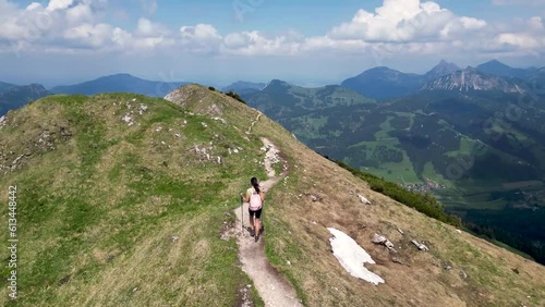 Young woman hiking on a mountain ridge with spectacular view photo