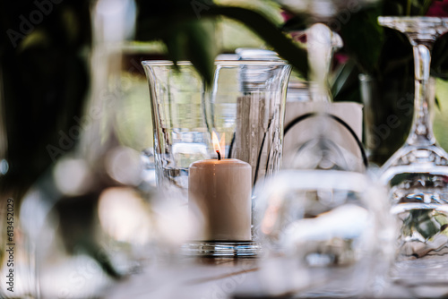 Burning candle in a glass jar. Cutlery close-up.