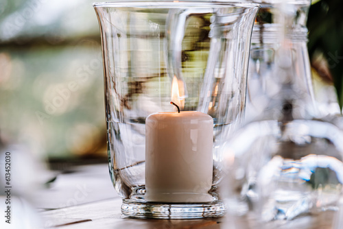 Burning candle in a glass jar. Cutlery close-up.