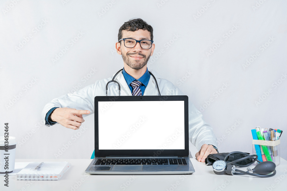Smiling doctor pointing at an advertisement on the laptop screen. Handsome doctor pointing at an advertisement on the laptop screen Smiling doctor pointing at an advertisement on the laptop screen. Handsome doctor pointing at an advertisement on the laptop screen