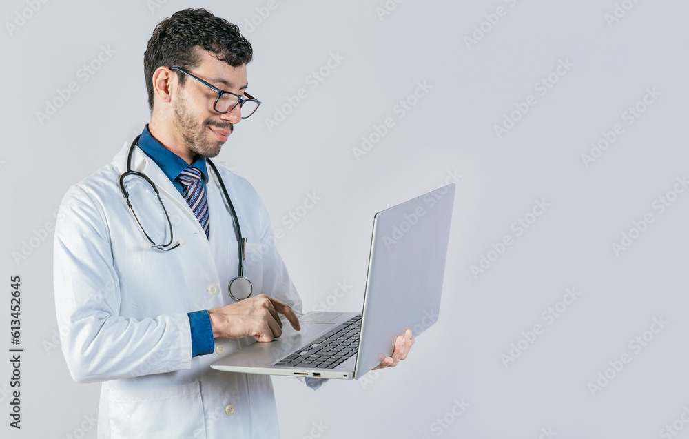 Handsome doctor using laptop isolated. Young doctor in glasses using notebook on isolated background, Smiling doctor standing using laptop isolated Handsome doctor using laptop isolated. Young doctor in glasses using notebook on isolated background, Smiling doctor standing using laptop isolated